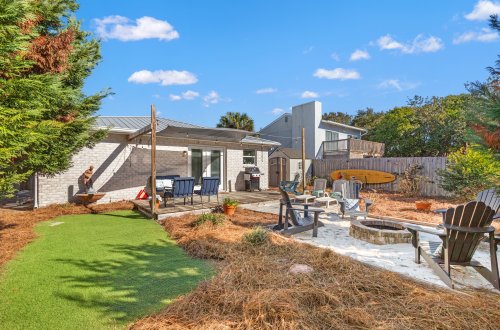 A backyard with a fire pit, seating area, and patio
