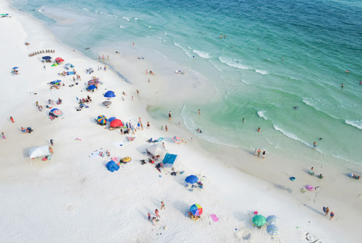 Aerial view of people enjoying the beautiful white sandy beaches and ocean