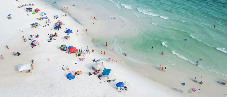 Aerial view of people enjoying the beautiful white sandy beaches and ocean