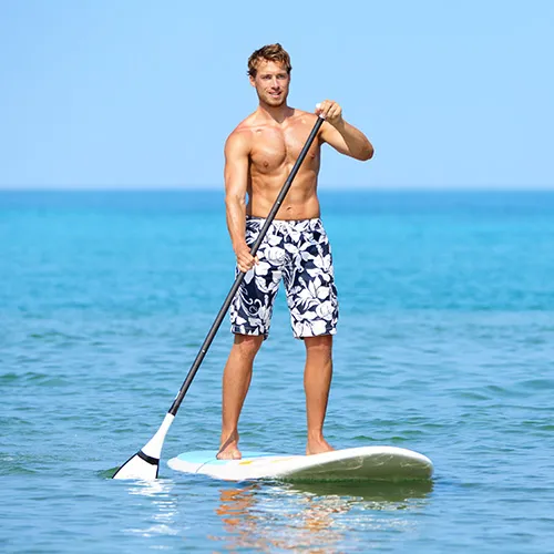 Man paddle boarding in ocean